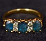 A modern 18 ct gold diamond and sapphire ring Set with three facet cut sapphires interspersed with