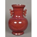 A Chinese porcelain twin handled vase Of baluster form with allover sang de boeuf glaze.