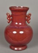 A Chinese porcelain twin handled vase Of baluster form with allover sang de boeuf glaze.