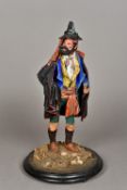 A 19th century papier mache model of a bearded huntsman Modelled wearing a dark cloak and holding a