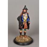 A 19th century papier mache model of a bearded huntsman Modelled wearing a dark cloak and holding a
