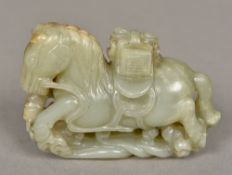 A Chinese carved white and celadon jade horse 10 cm wide.