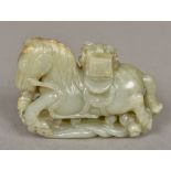 A Chinese carved white and celadon jade horse 10 cm wide.