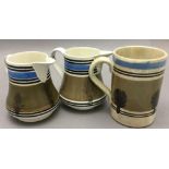 A pair of Victorian mochaware pint jugs Together with a T Green Ltd mochaware mug,