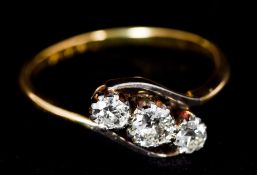 An 18 ct gold three stone diamond crossover ring CONDITION REPORTS: Generally in