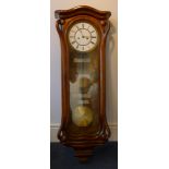 A 19th century Art Nouveau walnut framed eight day Vienna wall clock The white enamelled dial with