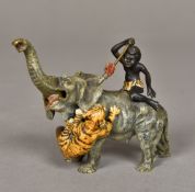 A cold painted bronze group Modelled as a tiger attacking an elephant with a Negro boy on its back.