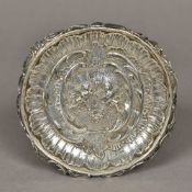 A Continental silver dish Of scrolling circular form centred with cherubs. 14 cm diameter.