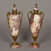 A pair of gilt metal mounted marble urns Each of scrolling twin handled form. Each 40 cm high.