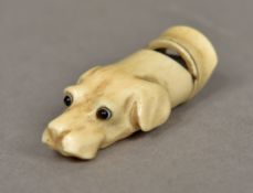 A carved ivory whistle Worked as a dog's head with glass eyes. 4.5 cm long.