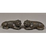 A pair of Chinese patinated bronze scroll weights Each formed as a dog-of-fo crouching on all fours.