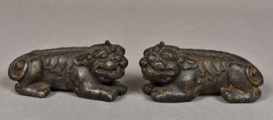 A pair of Chinese patinated bronze scroll weights Each formed as a dog-of-fo crouching on all fours.