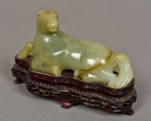 A Chinese carved green and russet jade horse Modelled recumbent,
