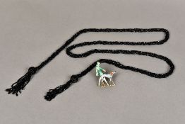 An Art Deco enamel decorated brooch Formed as a stylish lady walking a dog;