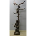 A Black Forest carved hall stand Formed as a bear beside a tree trunk with two bear cubs climbing.