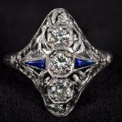 An Art Deco style platinum, diamond and sapphire set ring Of pierced domed navette form,