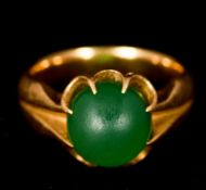 An unmarked gold and jade ring Set with a single jade cabochon.