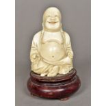 A Chinese carved ivory Buddha Modelled seated, on a carved wood plinth base. 11.5 cm high overall.