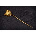 An unmarked gold and diamond stick pin The top formed as a fox mask with diamond inset eyes.
