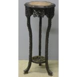 A 19th century Chinese carved hardwood urn stand The circular marble inset shaped top above the