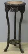 A 19th century Chinese carved hardwood urn stand The circular marble inset shaped top above the