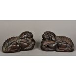 A pair of Chinese carved wooden models of dogs-of-fo Each modelled recumbent, one with a ball,