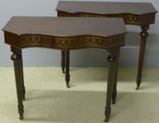 A pair of mahogany console tables Each angular serpentine top above a brass pique inlaid frieze,