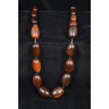 A Chinese carved horn graduated bead necklace Secured with a jade toggle. 58 cm long.