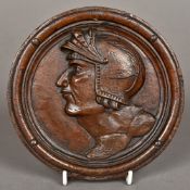 A 19th century Continental carved walnut roundel Carved with a profile bust of a soldier.