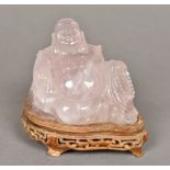A Chinese carved quartz Buddha Modelled recumbent on a carved wood plinth base. 10 cm high overall.