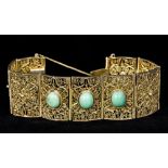 A Continental silver filigree bracelet Of segmented form, set with three turquoise cabochons.