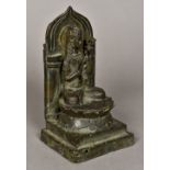 A Chinese cast bronze figure of Buddha Worked seated before an arcade, on a lotus leaf plinth,