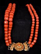 A two strand coral bead necklace Set with a coral mounted 18 ct gold clasp. 69 cm long.