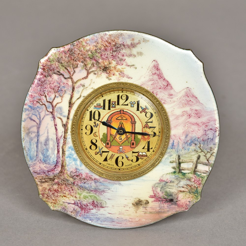 An enamel decorated desk clock The frame decorated with a mountainous country scene,