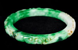 A Chinese jade 'slave' bangle Carved in the round with various beasts. 11 cm diameter.