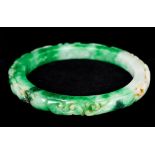 A Chinese jade 'slave' bangle Carved in the round with various beasts. 11 cm diameter.