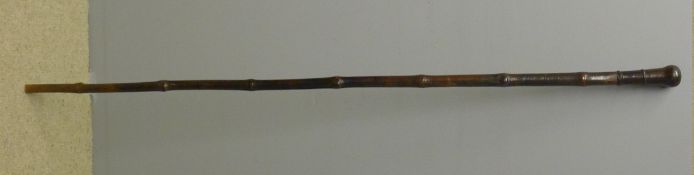 An 18th century Chinese bamboo staff The top with a turned wooden knop. 175 cm high.