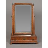 A George III walnut toilet mirror With bevelled plate and three curved frieze drawers,