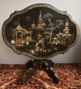 A 19th century mother-of-pearl inlaid chinoiserie tilt top centre table The hinged serpentine oval