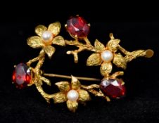 A 9 ct gold pearl and garnet set brooch Of flowering branch form. 4.5 cm wide.