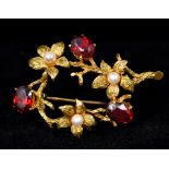 A 9 ct gold pearl and garnet set brooch Of flowering branch form. 4.5 cm wide.