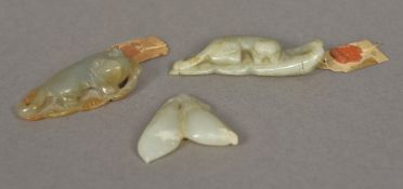 Three Chinese jade carvings Two modelled as recumbent cats, the other as fruit,