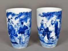 A pair of Chinese blue and white porcelain beakers Each decorated with figures in a fenced garden,