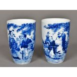 A pair of Chinese blue and white porcelain beakers Each decorated with figures in a fenced garden,