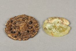 Two carved and pierced jade roundels One worked with mythical beasts flanking an ewer,