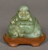 A Chinese carved jade model of Buddha Typically modelled seated, mounted on a carved wooden base.