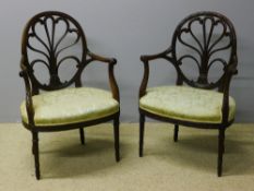 A pair of early 19th century mahogany shield back open armchairs The scroll carved pierced back