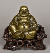 A Chinese cast bronze Buddha Modelled seated on a carved and pierced root wood throne. 21 cm high.