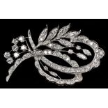 A diamond set platinum spray brooch Of entwined floral form. 5 cm long.