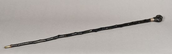An ebonised walking cane The ebony handle formed as the head of a Negro gentleman,